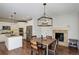 Bright dining space open to kitchen with a modern light fixture, fireplace, stainless appliances, and island at 4542 Valleybrook Dr, Highlands Ranch, CO 80130