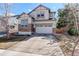 Inviting home showcasing a wide driveway, two-car garage, neutral stucco and stone accents at 4542 Valleybrook Dr, Highlands Ranch, CO 80130