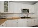 Well-lit kitchen features white cabinets, granite countertops, a stainless steel microwave, and tile backsplash at 4542 Valleybrook Dr, Highlands Ranch, CO 80130