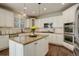 Well-lit kitchen features an island, stainless steel appliances, white cabinetry, and hardwood floors at 4542 Valleybrook Dr, Highlands Ranch, CO 80130