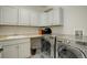 Well-lit laundry room features modern washer and dryer, basin sink, and cabinet storage at 4542 Valleybrook Dr, Highlands Ranch, CO 80130