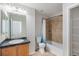 Bathroom features a shower-tub combo with tile surround, wood vanity, and tile floors at 18954 E 57Th Pl # D, Denver, CO 80249
