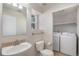 Bathroom with a pedestal sink and toilet. Laundry area features a newer washer and dryer at 18954 E 57Th Pl # D, Denver, CO 80249