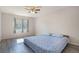 Bright bedroom featuring a ceiling fan, large window, and gray wood-look floors at 18954 E 57Th Pl # D, Denver, CO 80249