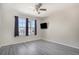 A spacious bedroom with a TV, large window, and modern gray wood-look floors at 18954 E 57Th Pl # D, Denver, CO 80249