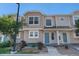 Charming multi-level townhouse showcasing neutral siding, beautiful landscaping, and an inviting blue front door at 18954 E 57Th Pl # D, Denver, CO 80249