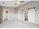 Spacious bedroom with a ceiling fan, plush carpeting and a sliding barn door to an ensuite bathroom at 4108 W 118Th Pl, Westminster, CO 80031