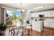 Eat-in kitchen featuring modern white cabinets, stainless steel appliances, and a glass dining table at 20293 E Progress Pl, Centennial, CO 80015