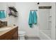 Bathroom featuring a shower-tub combo, shelves, and wood vanity at 5415 S Delaware St, Littleton, CO 80120
