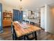 Open dining room leading to the kitchen offering a unique chandelier and beautiful wood floors at 2619 Mountain View Ave, Franktown, CO 80116