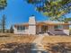 Charming single-story house with a brick facade, mature trees, and a welcoming walkway leading to the front door at 2619 Mountain View Ave, Franktown, CO 80116