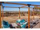 The backyard pergola offers mountain views, paired with a cozy outdoor lounge setting with comfortable seating around a table at 2619 Mountain View Ave, Franktown, CO 80116