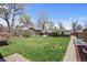 Green backyard with lush lawn, mature trees and privacy fence at 2565 Gray St, Edgewater, CO 80214