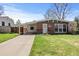 Charming brick home featuring a well-manicured lawn, covered carport, and a cozy front porch area at 2565 Gray St, Edgewater, CO 80214