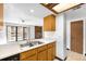 Bright kitchen with skylight, wood cabinets and view into the adjacent living area with fireplace at 4896 S Dudley St # 6-5, Littleton, CO 80123
