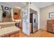 Kitchen area with stainless steel refrigerator, and a glimpse of the staircase and countertop at 6406 Silver Mesa Dr # F, Highlands Ranch, CO 80130