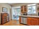 Well-lit kitchen with wooden cabinets and stainless steel dishwasher, next to sliding glass door at 6406 Silver Mesa Dr # F, Highlands Ranch, CO 80130