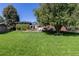 Overhead shot of a large backyard with green grass, a flower garden, and a patio area at 930 Reed Ct, Lakewood, CO 80214