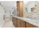 Bright bathroom featuring granite counters, tiled backsplash, and a large oval mirror at 930 Reed Ct, Lakewood, CO 80214