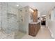 Modern bathroom featuring a tiled shower with glass door and a wood vanity at 930 Reed Ct, Lakewood, CO 80214