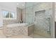 Relaxing bathroom showcasing a soaking tub and glass enclosed shower at 930 Reed Ct, Lakewood, CO 80214