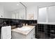 Updated bathroom featuring a granite countertop, black tiled backsplash, and modern fixtures at 930 Reed Ct, Lakewood, CO 80214