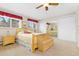 Sunlit bedroom featuring wood furniture, plush carpeting, and mirrored closet doors at 930 Reed Ct, Lakewood, CO 80214