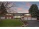 Charming red brick and white home with a well-manicured lawn, complemented by a neatly paved driveway at 930 Reed Ct, Lakewood, CO 80214
