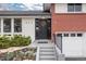 Charming home entrance with a well-maintained front door, fresh landscaping, and a brick accent wall at 930 Reed Ct, Lakewood, CO 80214