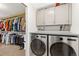Functional laundry room with front loading washer/dryer and storage cabinets at 930 Reed Ct, Lakewood, CO 80214