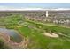 An aerial view of a golf course community with a pond and mountain backdrop at 1122 Olympia Ave # 12H, Longmont, CO 80504