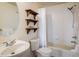 Cozy bathroom with a sink, toilet, tub-shower combo, and open shelving for towels at 1122 Olympia Ave # 12H, Longmont, CO 80504