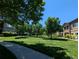 Lush, green community lawn lined with trees offers a park-like setting for residents at 1122 Olympia Ave # 12H, Longmont, CO 80504