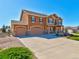 A beautiful home boasts a well-maintained lawn and a spacious driveway leading to a three-car garage at 1235 Woodmoor Acres Dr, Monument, CO 80132