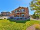 Charming two-story home with a well-manicured front lawn, complemented by vibrant flowering plants and lush greenery at 1235 Woodmoor Acres Dr, Monument, CO 80132