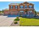 Inviting two-story home featuring a three-car garage, a charming front porch, and meticulously landscaped front yard at 1235 Woodmoor Acres Dr, Monument, CO 80132