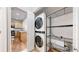 Laundry room offers stacked washer and dryer, with a wire rack shelf for additional storage at 17926 E 104Th Way # C, Commerce City, CO 80022