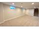 Finished basement featuring neutral carpeting, a window and a door at 8239 Nola Dr, Denver, CO 80221