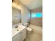 Bathroom featuring a tiled bathtub, a window, and a vanity with sink at 8239 Nola Dr, Denver, CO 80221