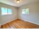 Bright bedroom with hardwood floors and natural light from two windows at 8239 Nola Dr, Denver, CO 80221