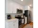 Updated kitchen featuring white cabinets, stainless steel appliances, and quartz countertops at 8239 Nola Dr, Denver, CO 80221
