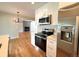 Stylish kitchen featuring stainless steel appliances, white cabinets, and hardwood floors at 8239 Nola Dr, Denver, CO 80221