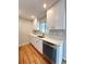 Clean kitchen featuring white cabinetry, stainless steel dishwasher, and hardwood floors at 8239 Nola Dr, Denver, CO 80221