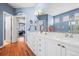 Spacious bathroom featuring double sinks, white cabinetry, and an open doorway to the bedroom at 6700 W Dorado Dr # 51, Littleton, CO 80123