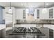 Close-up view of a modern kitchen island with a cooktop and stainless steel appliances at 6700 W Dorado Dr # 51, Littleton, CO 80123