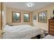 Comfortable bedroom with three windows providing lots of natural light and views of the surrounding landscape at 26367 Pressler St, Conifer, CO 80433