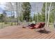 Outdoor deck featuring patio furniture surrounded by serene aspen trees and natural landscapes at 26367 Pressler St, Conifer, CO 80433
