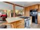 Open-concept kitchen with island cooktop, black refrigerator, and seamless flow into the living area at 26367 Pressler St, Conifer, CO 80433