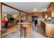 Well-lit kitchen with wood cabinets, center island, and open view into the adjacent living room at 26367 Pressler St, Conifer, CO 80433