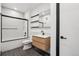Modern bathroom features a shower over tub, a wood vanity, and dark fixtures at 1601 Park Ave # 106, Denver, CO 80218